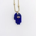 Detail van lapis lazuli Hamsa hand hanger met boze oog aan een gouden ketting - Marineblauw