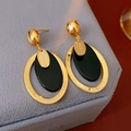 Macro shot of gold oval resin earrings with handmade coin tag on velvet display - Black Oval Pendant Style / Black