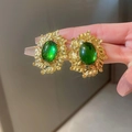 Vintage French style gold leaf earrings with green oval gemstone shown on ear - Green Oval Leaf (24# Silver Pin)