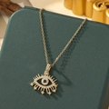 Collier œil maléfique doré avec zircons et pierre bleue sur un coffret vert - A18-or