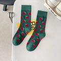 Dark green crew socks with vibrant red strawberry patterns on a minimalist desk - One Size / Dark Green Strawberry
