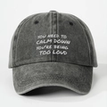 Dettaglio del ricamo bianco su un cappellino in cotone grigio scuro lavato - Nero Lavato
