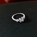 Détail d'une bague trèfle argentée sertie de zircons avec des bords perlés fins - Bague / Argent