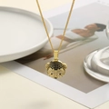 Nahaufnahme einer goldenen Halskette mit einem kristallbesetzten Affen-Anhänger auf Teller - Affen-Muster (ZYN-DMK678G-A)