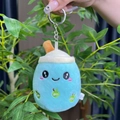 Close-up of blue plush milk tea cup keychain with cartoon embroidery and metal ring - 11cm / Blue Round Eye