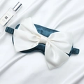 Navy blue silk sleep mask with white satin bow detail and elastic strap shown on silk - Dark Green