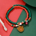 Detailed view of Christmas beaded bracelet with reindeer charm and bells on festive background - Elk
