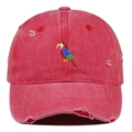 Close-up of colorful parrot embroidery and distressed details on a washed red baseball cap - Watermelon red