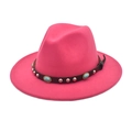 Gros plan sur un chapeau fedora rose rouge avec bande en cuir et ornements turquoise - Rose rouge
