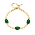 Close-up of golden flat snake chain necklace with green emerald-style gemstones - Bracelet (B102)