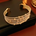 Detailed view of layered gold beaded bracelets on a black leather jewelry box - Gold
