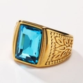 Macro shot of gold men's ring with large rectangular blue gemstone and leaf engravings - Gold Aqua Blue Gemstone