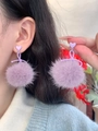 Nahaufnahme eleganter lilafarbener Plüsch-Ohrringe mit Herzsteckern am Model - Silberstift Herz Schleife Plüschball Stil / Lila