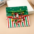 Detail of Christmas bracelet set with enamel pendants on Merry Christmas display card - S324 2Pcs Red Green Braided Rope Bracelet Set With Tree/Snowman/Deer/Bell Charms