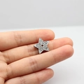 Ciondolo fai-da-te a stella argentata con strass bianchi tenuto tra le dita per scala - 10MM Cromo Strass - Stella