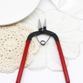Detail of red-handled jewelry pliers with black metal tips on a lace surface - Small Bent Nose Pliers / Red Handle