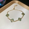 Detail of gold clover bracelet with green malachite stones and sparkling zircons - Green
