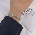 Silver woven wheat pattern titanium steel C-shaped cuff bracelet shown on wrist - Bangle / Steel