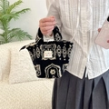 Vue détaillée du sac à main en peluche avec motif rétro noir et blanc et fermeture - Totem de Style Ethnique