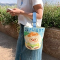 Cream canvas bucket bag with blue straps and cute puppy graphic in sunlight - Summer Cute Rabbit