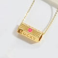 Detailed close-up of a gold Lucky pendant with a pink heart and zircon inlay - Rose Red