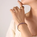Elegante bracciale placcato oro 18K con zirconia viola e anello con pietra nera su modella - Bracciale Elastico / Oro Zirconia Viola