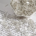 Perline di vetro argentate per gioielli fai-da-te in piatto di ceramica bianca su libro - Argento