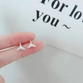 Close-up of minimalist 925 silver whale tail stud earrings with vintage embossed texture - Dolphin Tail / Silver