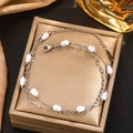 Double-layered silver stainless steel bracelet with baroque pearls on a luxury jewelry box - 18K Gold / Silver
