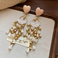 Detalle de pendientes de corazón boho con cuentas de madera y borlas de seda - Pendientes de Borla de Corazón Vintage Francés / Marrón dorado