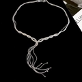 Detail of silver multi-layer fringe necklace with polished tassels on black velvet - Silver