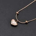 Collar de corazón minimalista en oro rosa con incrustación de nácar blanco sobre fondo oscuro - Oro rosa