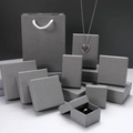 Detalle de cajas para joyas en gris con textura litchi y bolsa de regalo a juego - 5*5*3cm / Gris