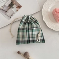 Green and black plaid drawstring pouch on a desk with laptop and makeup brushes - Diagonal Green-Black Grid