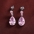 Elegant pink teardrop zircon earrings with pear-cut stone on red textured fabric - Pink