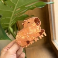 Detail of cute orange translucent capybara hair claw clip with carved facial features - Lying Capybara Orange Acetate Claw Clip