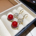Macro di eleganti orecchini di perle rosse con zirconi incastonati in una scatola regalo - Orecchini a Gancio Rossi