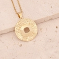 Macro detail of golden 18K gold zodiac pendant with hollow hex pattern on beige stone - 6#Cancer