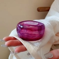 Detail of purple acrylic bangle with feather-like marble texture on a female wrist - Purple