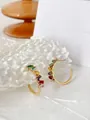 Detailed close-up of C-shaped gold-plated earrings with rainbow gradient square zircons - Round Colorful