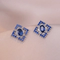 Macro view of geometric rhodium-plated earrings with blue zircon in a diamond shape - Blue Rhombus Gemstone Style (E0692) / Silver