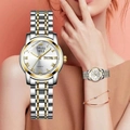 Close-up of silver steel quartz watch with dual calendar display and gold accents - Roman Numeral Two-Tone White Dial