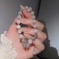 Detail eines Opalperlen-Armbands mit einem funkelnden Strass-Schmetterlingsanhänger - Silberweiß (16# Armband-Silberweiß)
