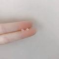 Minimalist 925 sterling silver hollow star stud earrings shown on finger for scale - Hollow Star / Silver