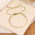 Detail of bohemian woven beaded bracelet on a stone tray with natural textures - Grass Green