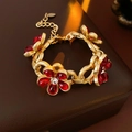 Dettaglio di un bracciale vintage dorato con cinque fiori in vetro rosso e cristalli - Bracciale in Oro (WB191) / Bracciale-Rosso