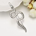 Detail of silver snake hair clip with textured scales and rhinestone eyes on white backdrop - Silver Snake
