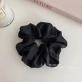 Detail of a large black silk scrunchie with satin texture on a minimalist background - Medium 8cm / Black