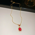 Close-up of 18k gold plated necklace featuring a red oval gemstone and zircon halo - Chain Only / Gold-Red