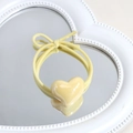 Elastic yellow heart hair tie with bow detail on a decorative white heart mirror - Heart / Yellow